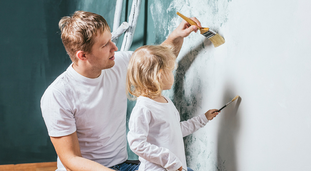 Man and child painting wall in PPG Paints